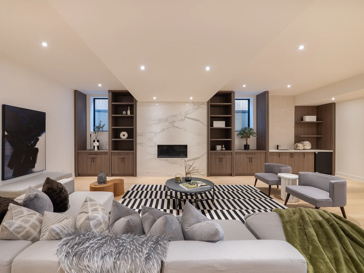 Finished lower level with marble fireplace, built-ins and wet bar — Mona custom home by Studio Kimi