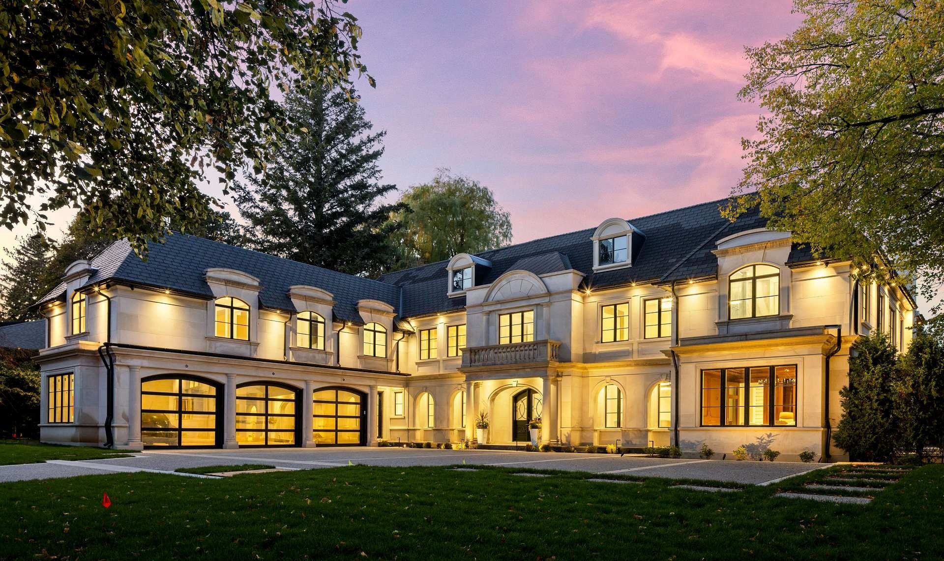 Bayview Ridge limestone exterior with reflecting pool at dusk — Studio Kimi interior design in Toronto