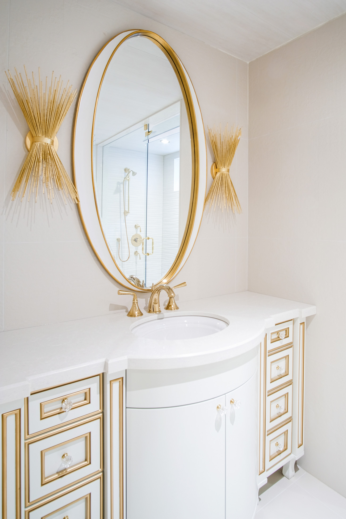 Burrowhill basement bathroom with white vanity and gold oval mirror — Studio Kimi, Lorne Park Mississauga