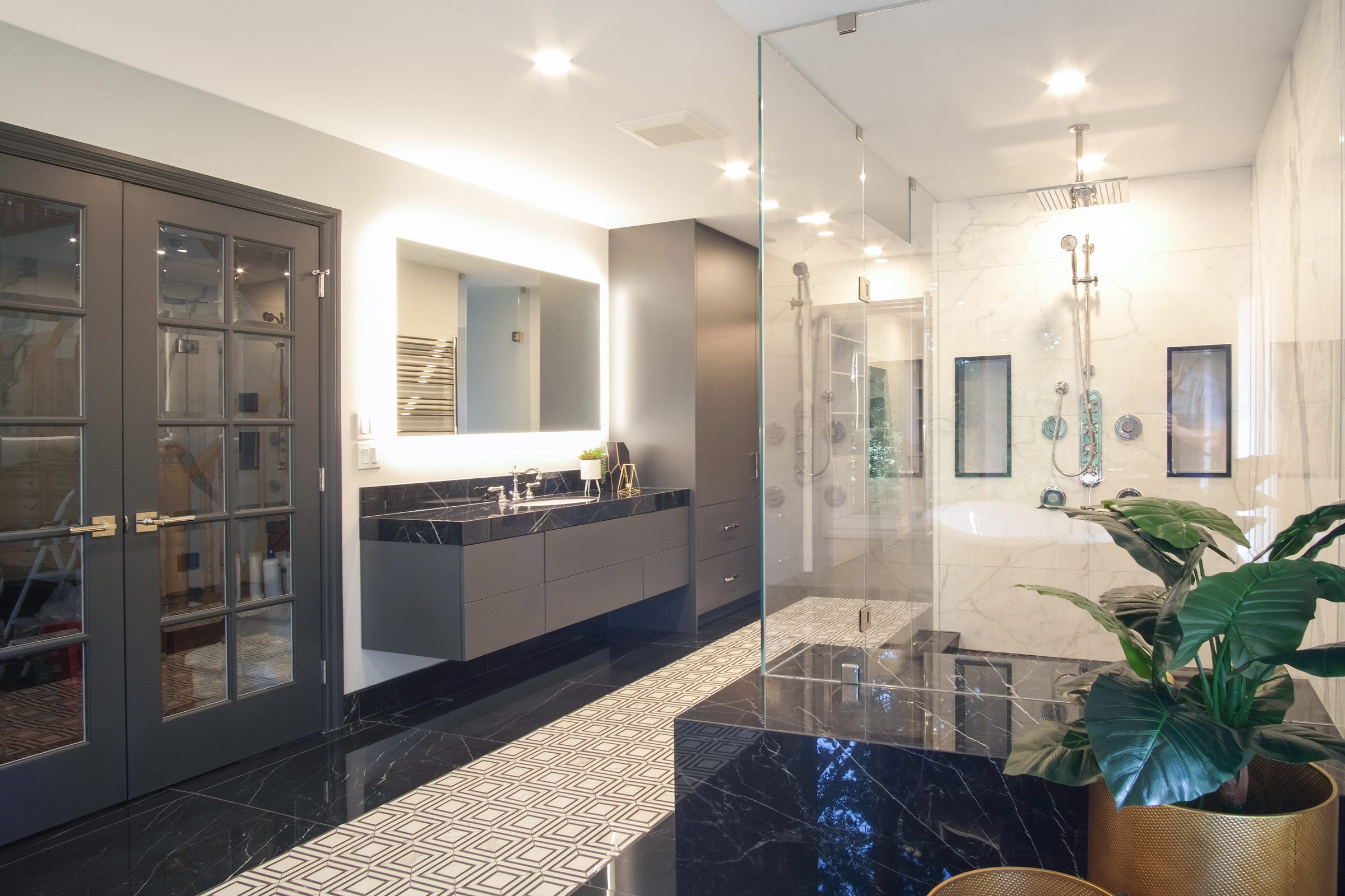 Double vanity with backlit mirrors over a two-tone patterned tile floor, Gregwood