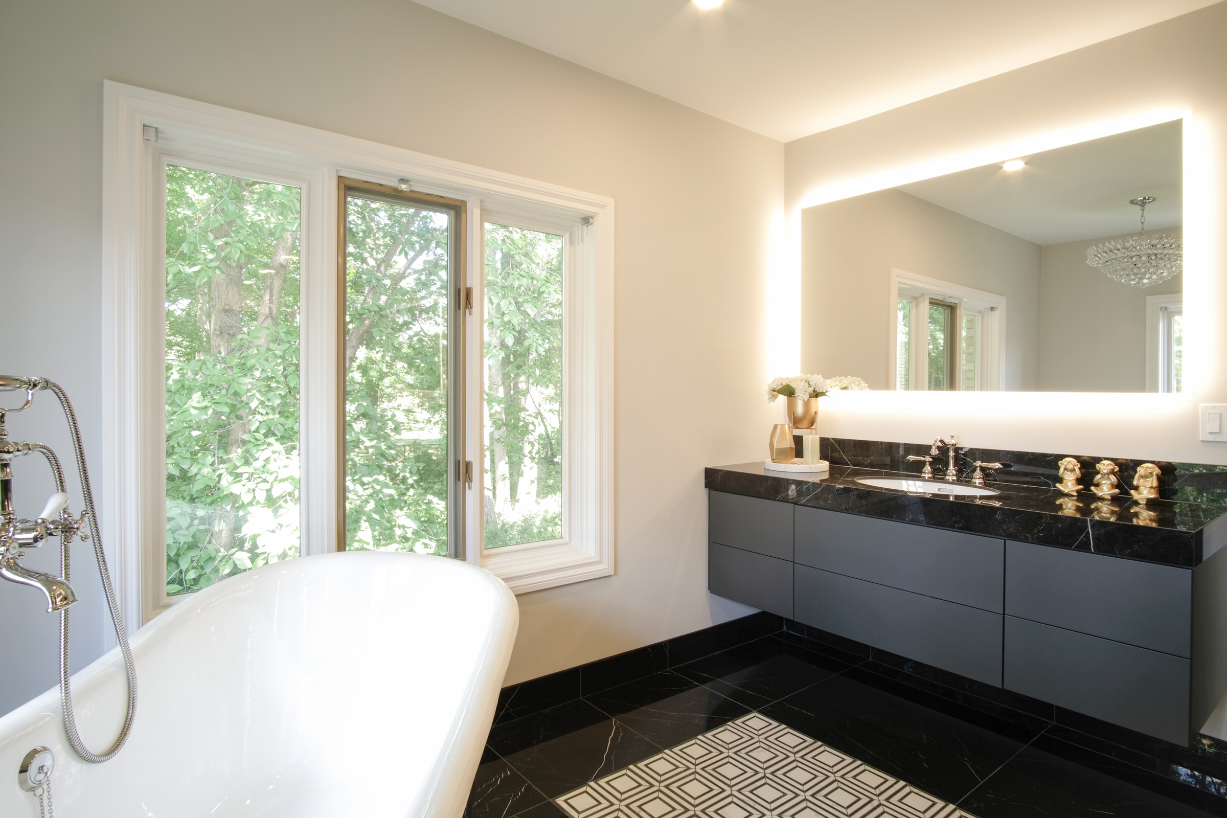 Freestanding tub beneath a window with a brass floor filler, primary ensuite, Mississauga