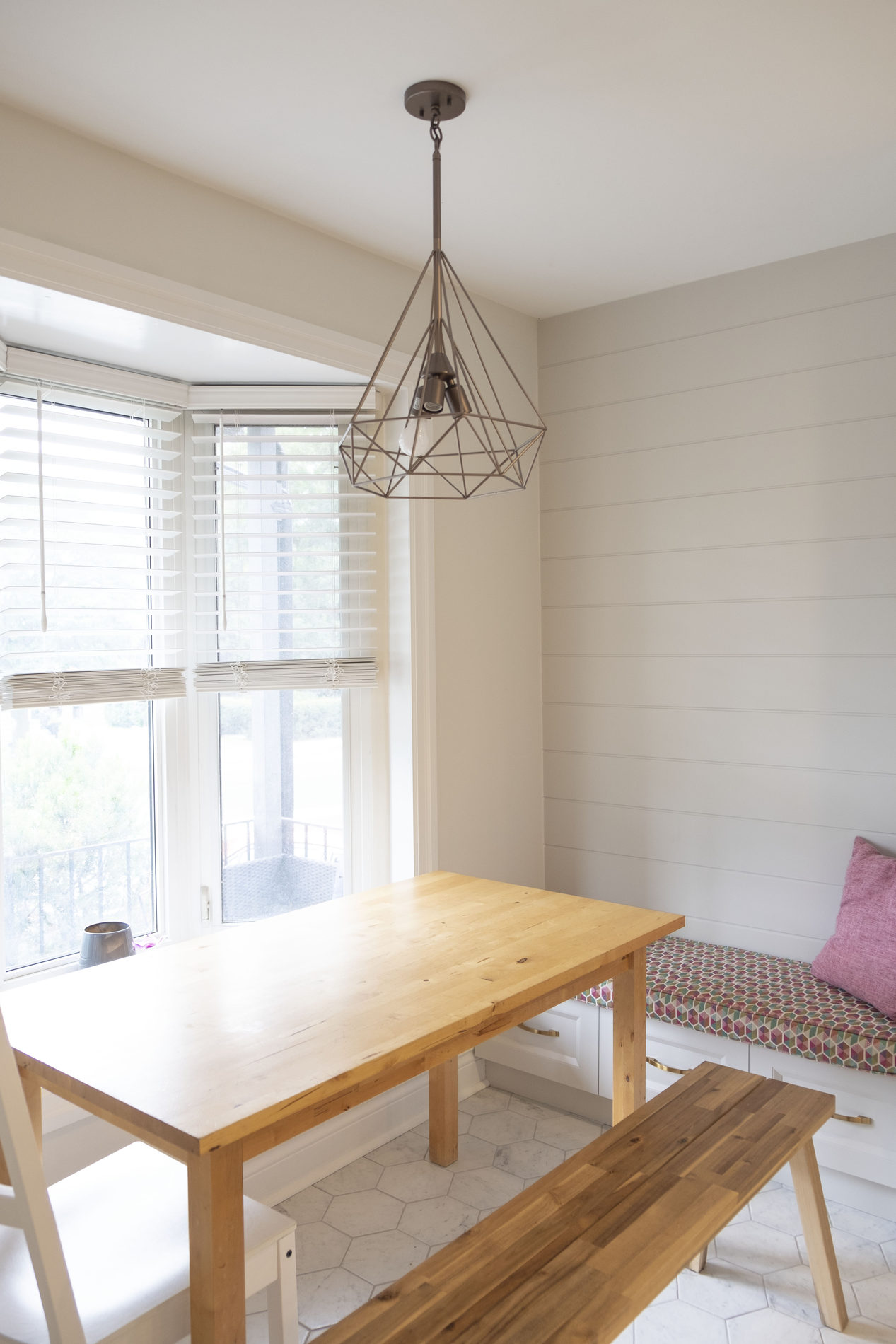 Dining area with a wood table and wire pendant in an Etobicoke main-floor renovation by Studio Kimi