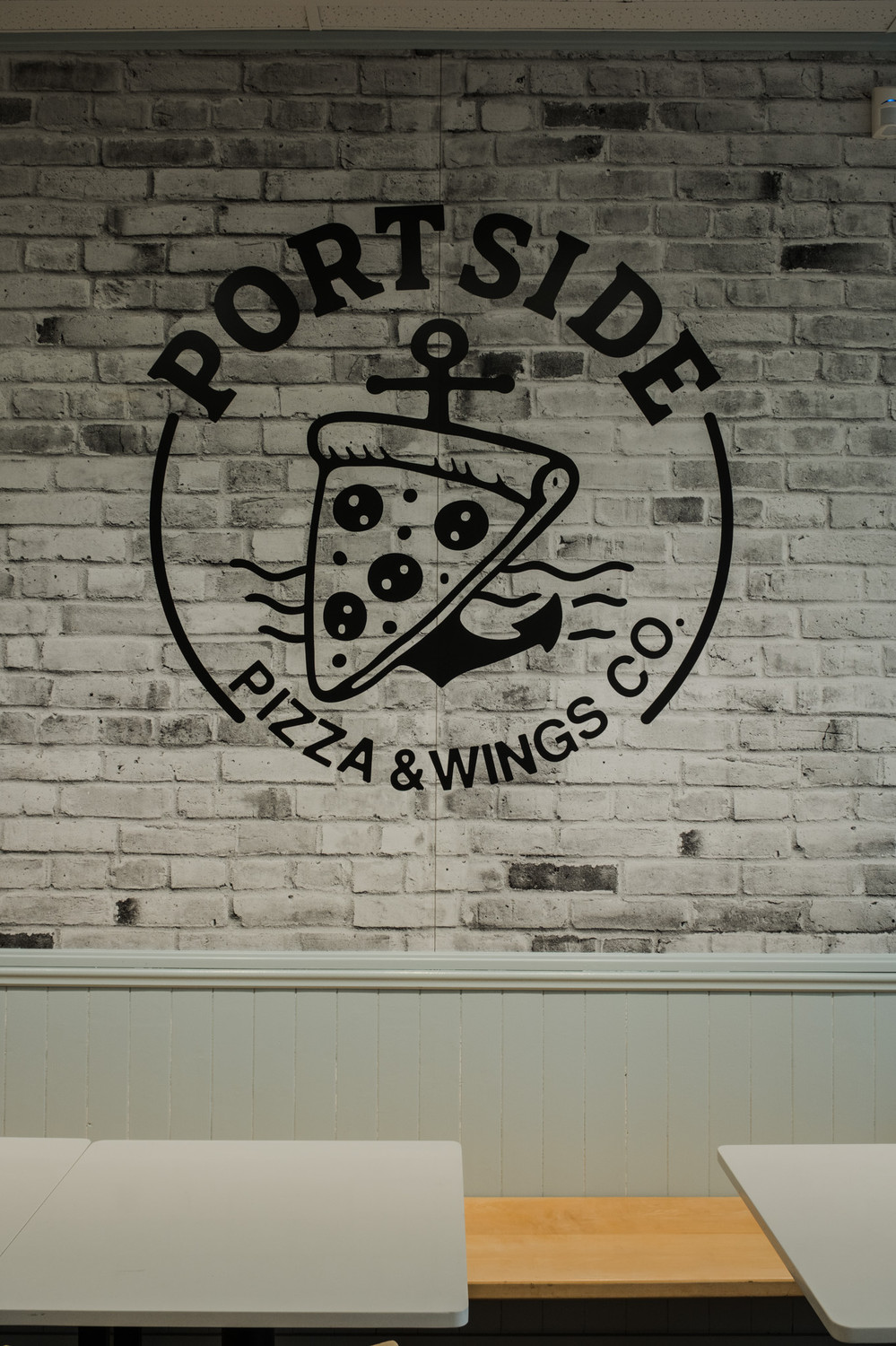 Portside brand wall with the logo on white brick